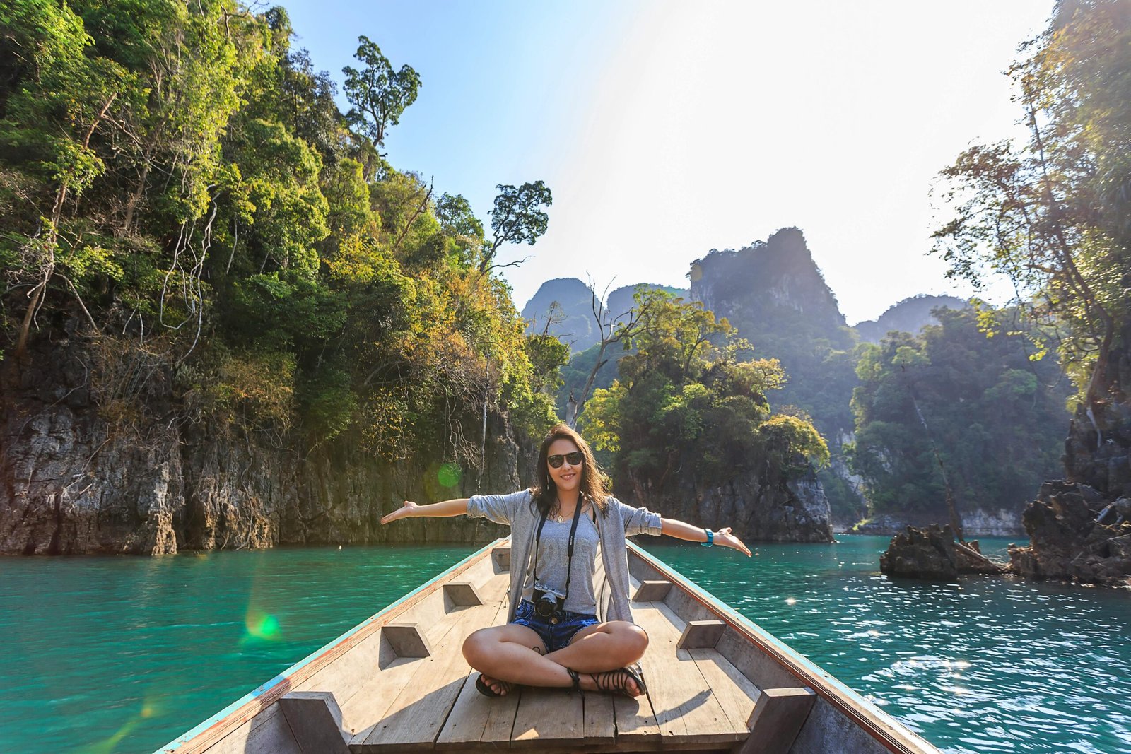 pexels-photo-1371360-1371360-1 Asian woman relishing a serene boat journey through the lush karst landscape of Thailand's Khlong Sok.